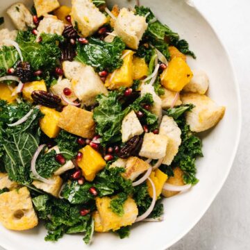 A white salad bowl filled with butternut squash panzanella salad.