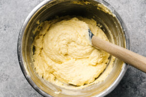 Healthy cornbread batter in a mixing bowl with a rubber spatula.