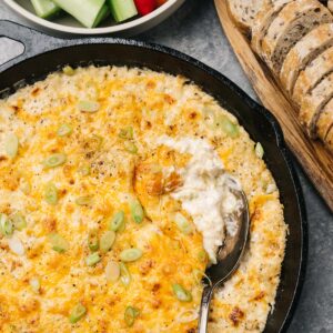 Hot crab dip fresh from the oven with a silver serving spoon.