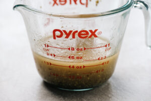 Bacon vinaigrette in a glass measuring cup.