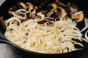 Sautéed mushrooms and onions in a cast iron skillet.