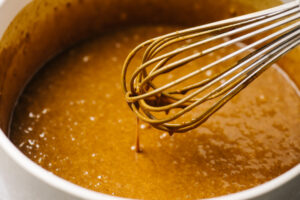 Gingerbread cake batter running off a wire whisk.