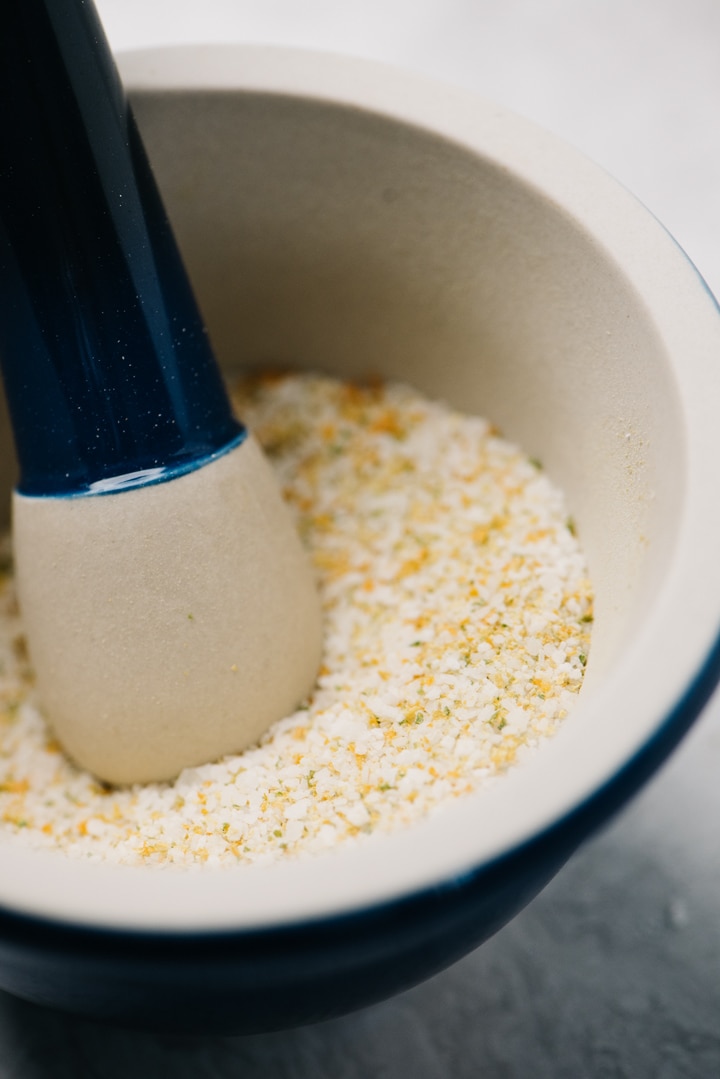 Kosher salt in a mortar and pestle with crushed citrus zest.