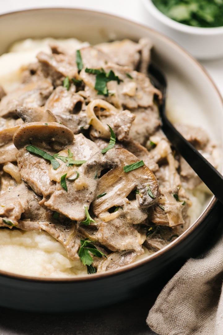 Side view, a bowl of keto beef stroganoff with cauliflower puree. 