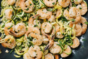 Keto shrimp scampi tossed with zucchini noodles in a 12" skillet.