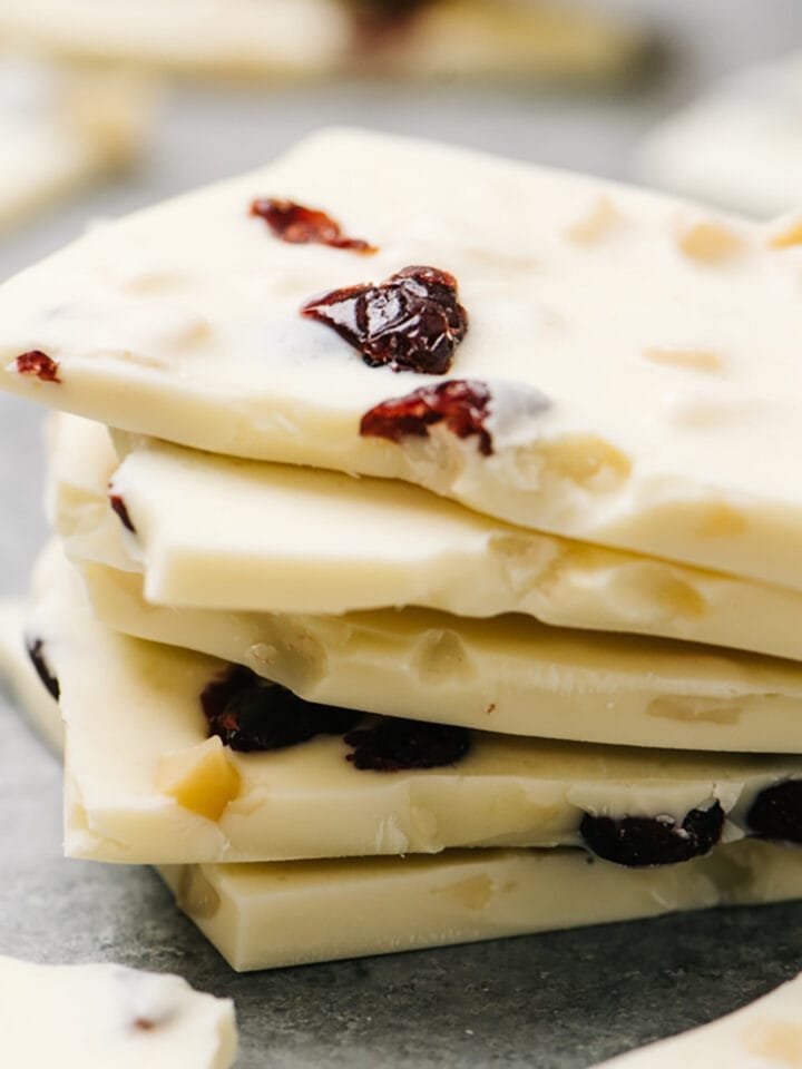 White chocolate bark pieces stacked on top of a cement background.