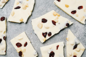 Several chunks of white chocolate bark spread across a concrete background.