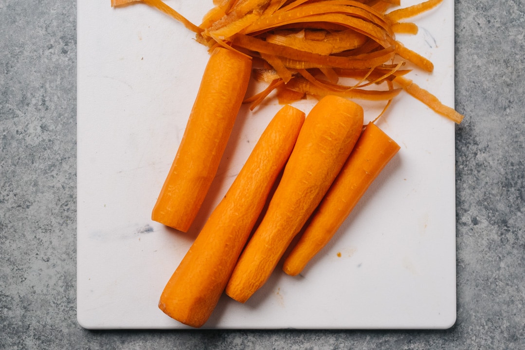 Peeled carrots on a cutting board.