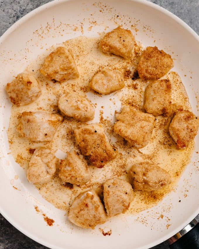 Golden brown crispy chicken bites in a skillet.