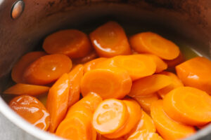 Cooked glazed carrots in a pot.