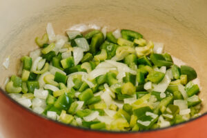 Sauteed green onion, celery, and onion in a red dutch oven.