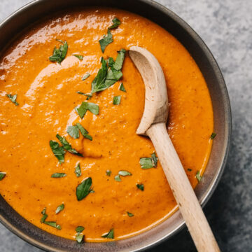 Romesco sauce in a grey bowl with a wood spoon.
