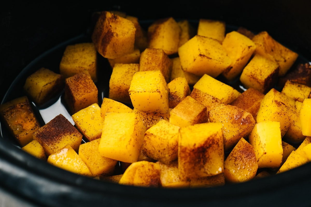 Cooked butternut squash cubes in a crockpot.