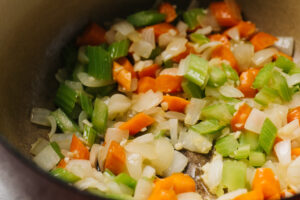 Chopped carrots, onion, and celery with minced garlic, sautéing in a dutch oven.