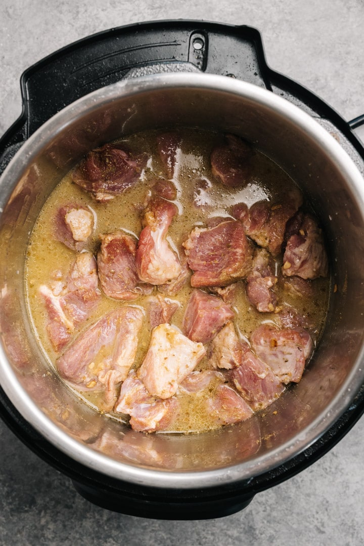 The ingredients for pressure cooker carnitas in an instant pot before cooking.