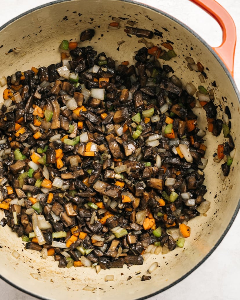Diced portobello mushrooms sautéed with onion, celery, carrot, and garlic in a red dutch oven.