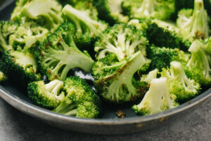Side view, broccoli sautéing in a skillet.