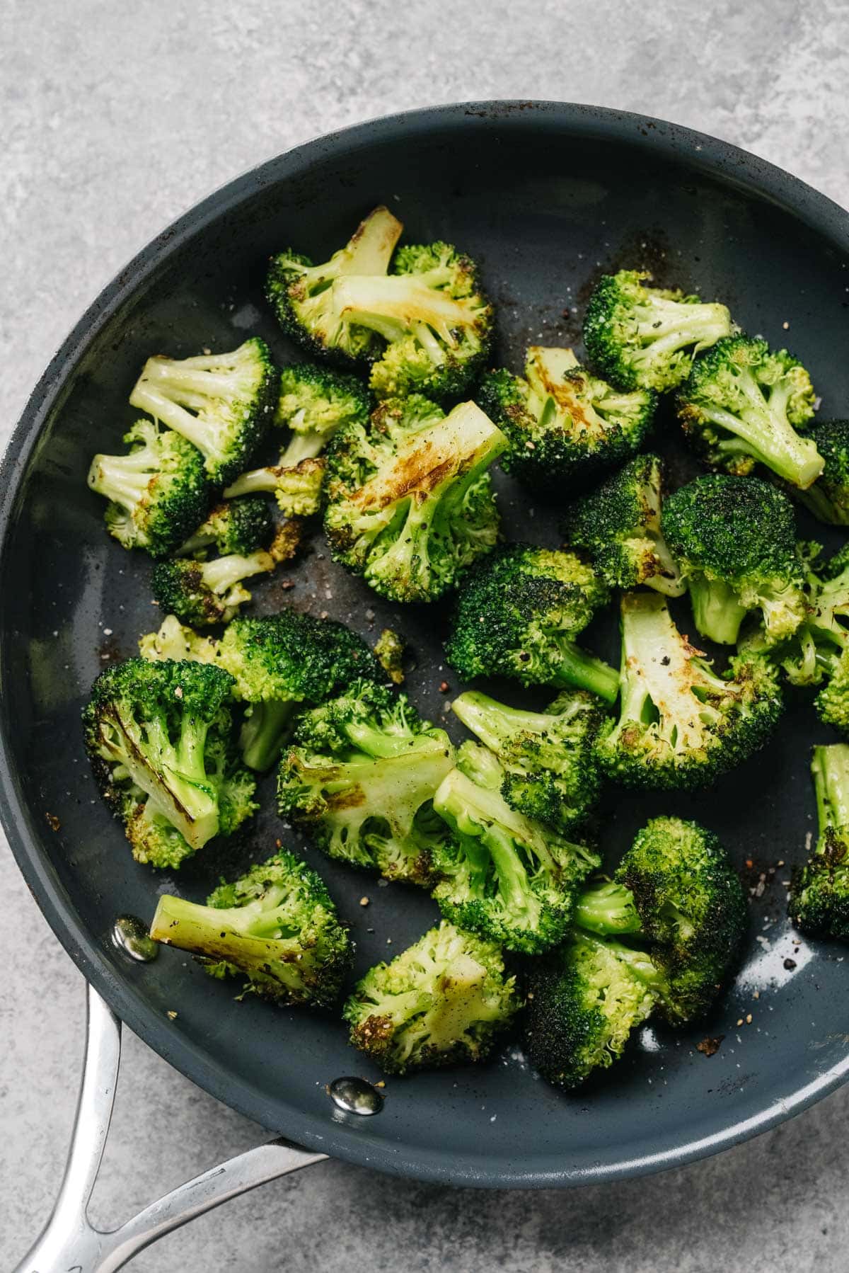 From overhead, sautéed broccoli in a skillet with olive oil and garlic.