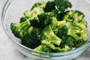Steamed broccoli florets in a glass bowl.