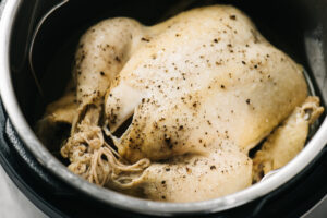 A cooked whole chicken in an instant pot.