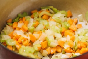 Carrots, celery, and onion sautéed until soft in a red dutch oven.
