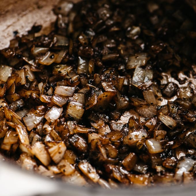 Balsamic vinegar added to sautéed onions in a dutch oven.