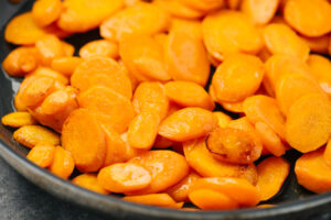 Side view, steamed carrots in a skillet.