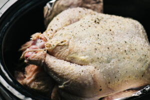 A whole trussed chicken in a slow cooker.