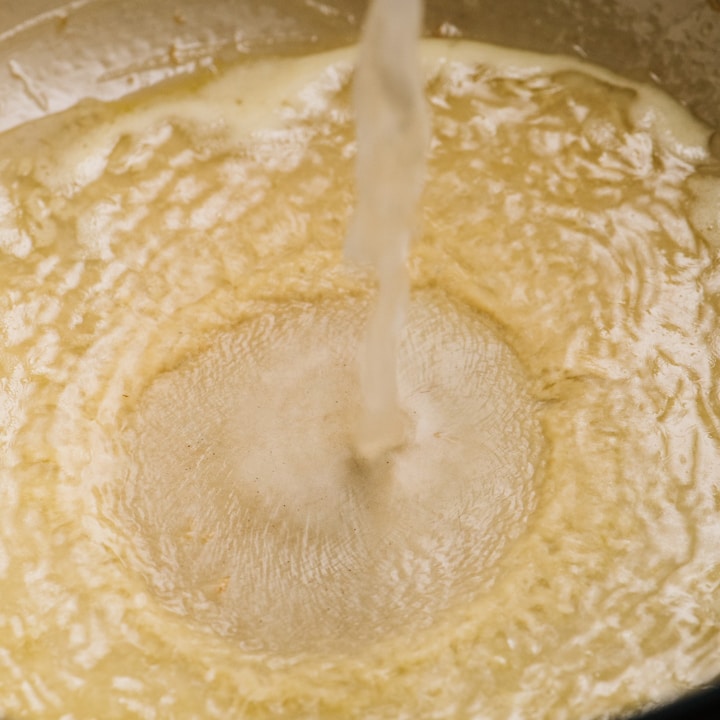 Adding pasta water to a roux.