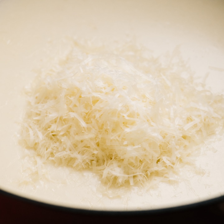 Finely shredded parmesan cheese added to a creamy pasta sauce.
