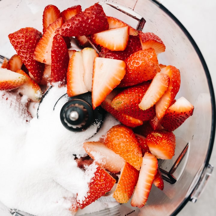 Quartered strawberries and sugar in a blender.
