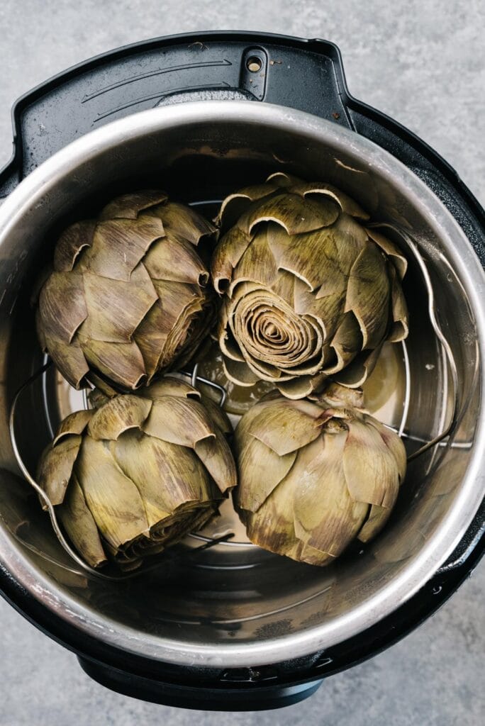  Four whole steamed artichokes in an instant pot.