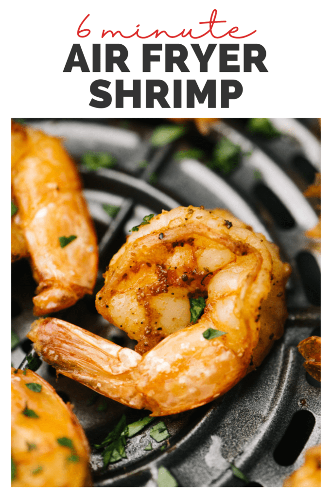 Side view, cook shrimp in the basket of an air fryer garnished with parsley with title bar that reads "6 minute air fryer shrimp".