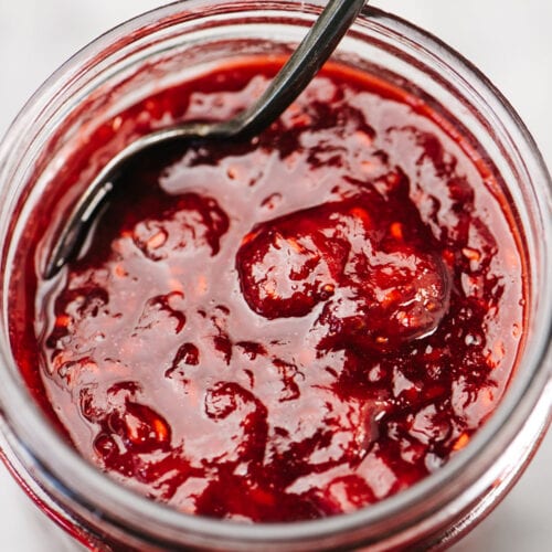 Side view, a close up image of berry compote in a canning jar.