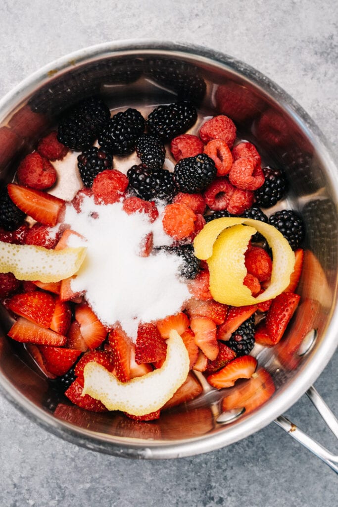 Chopped strawberries, raspberries, and blackberries combined with sugar, lemon juice, and lemon peel in a small saucepot.
