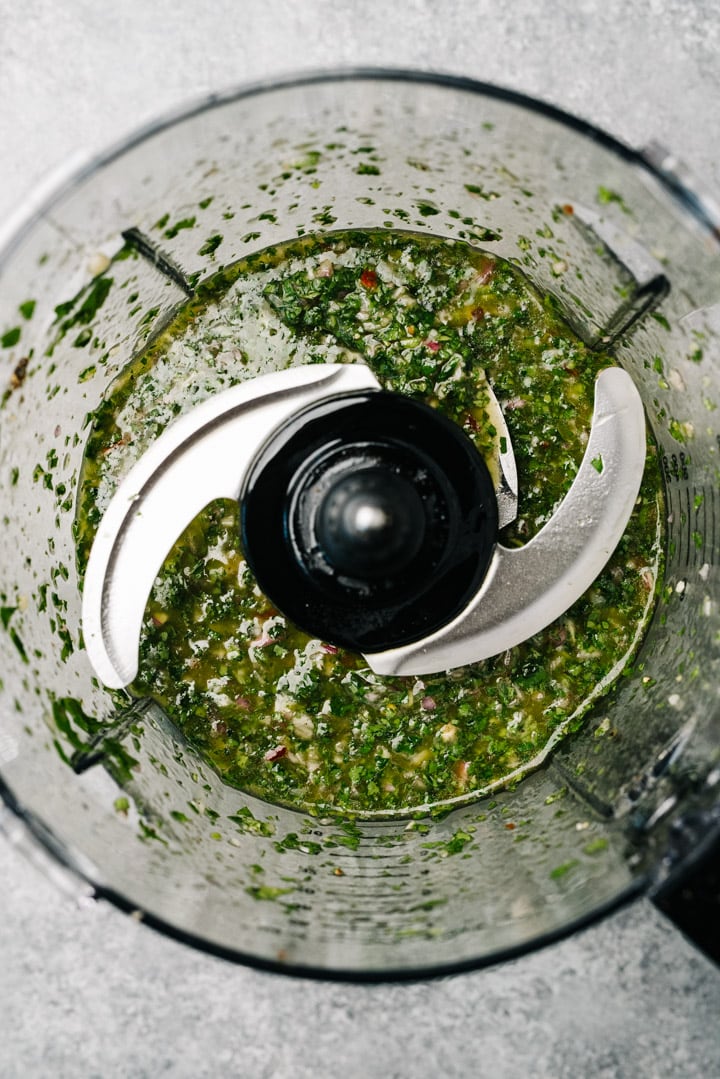 Chimichurri sauce in the bowl of a food processor.