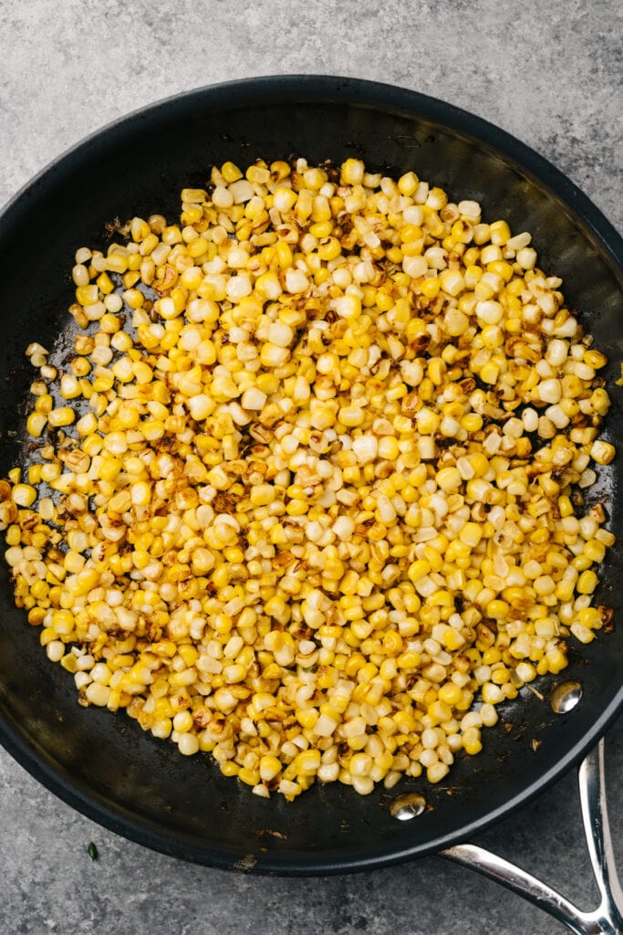 Sautéed fresh corn kernels in a skillet.