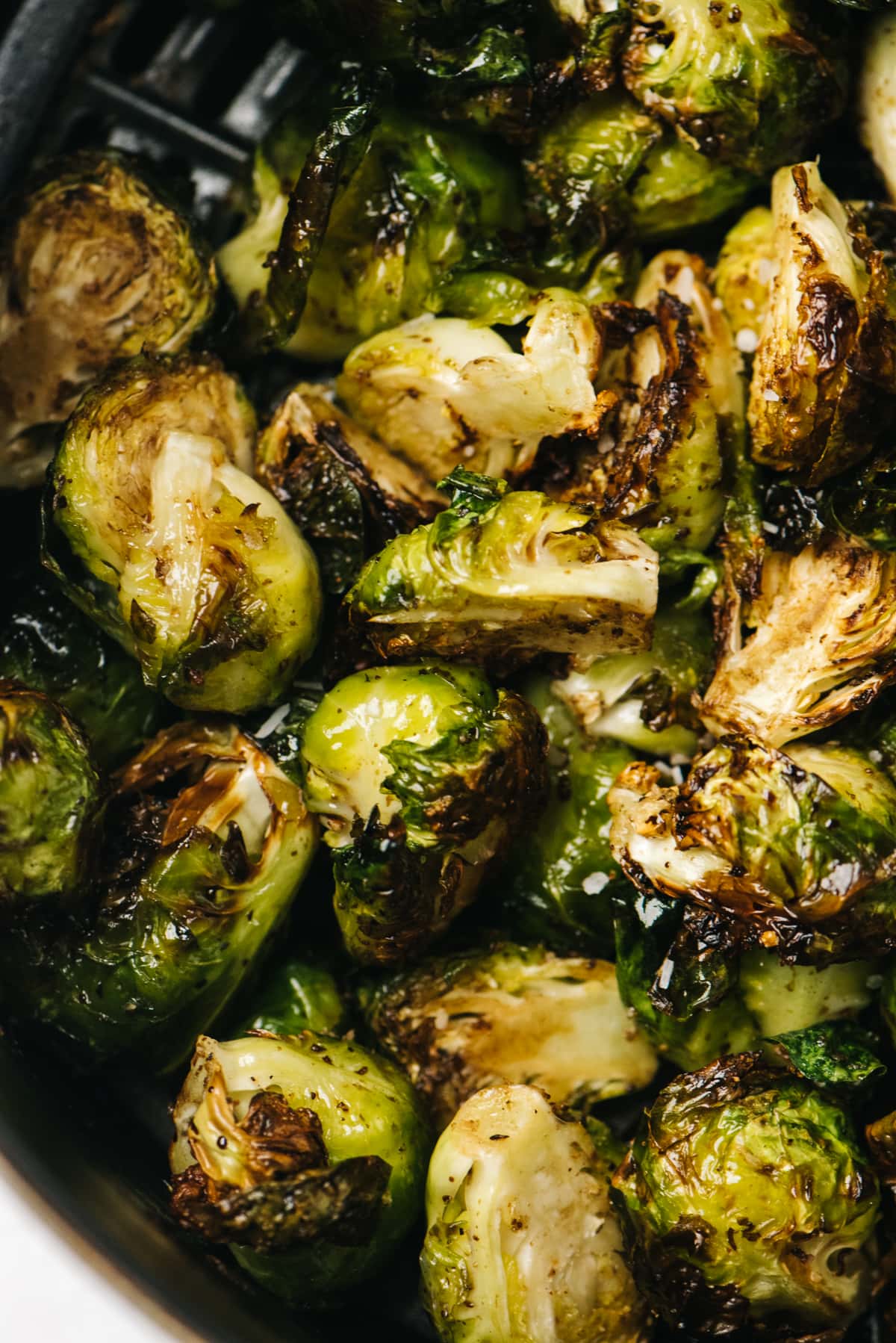 From overhead, balsamic brussels sprouts in an air fryer basket.