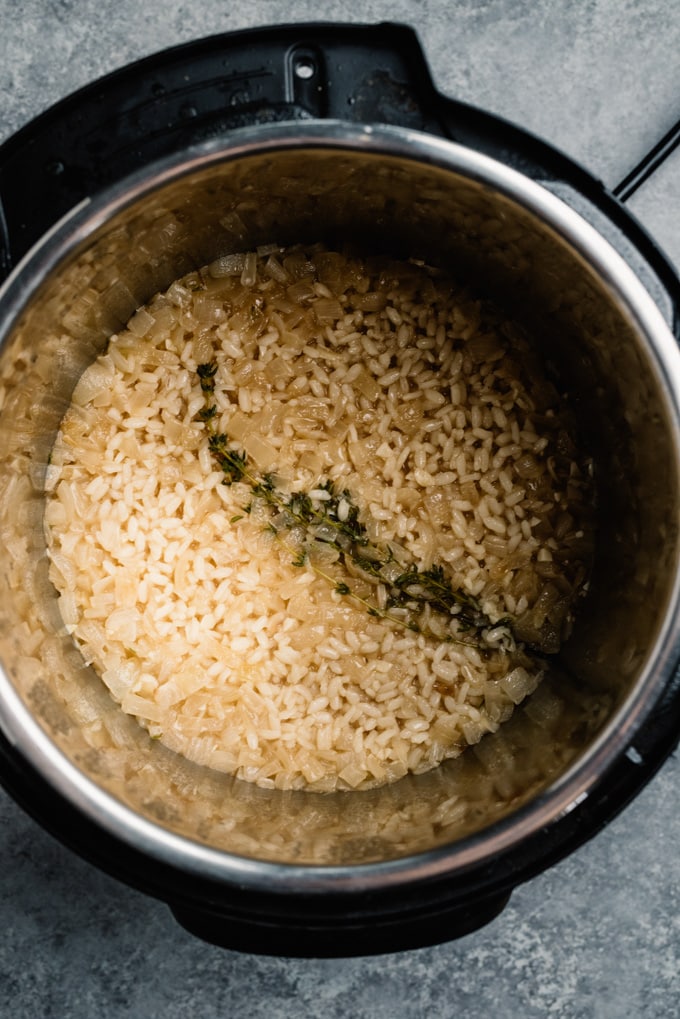 Cooked risotto rice with onions and thyme in an instant pot.