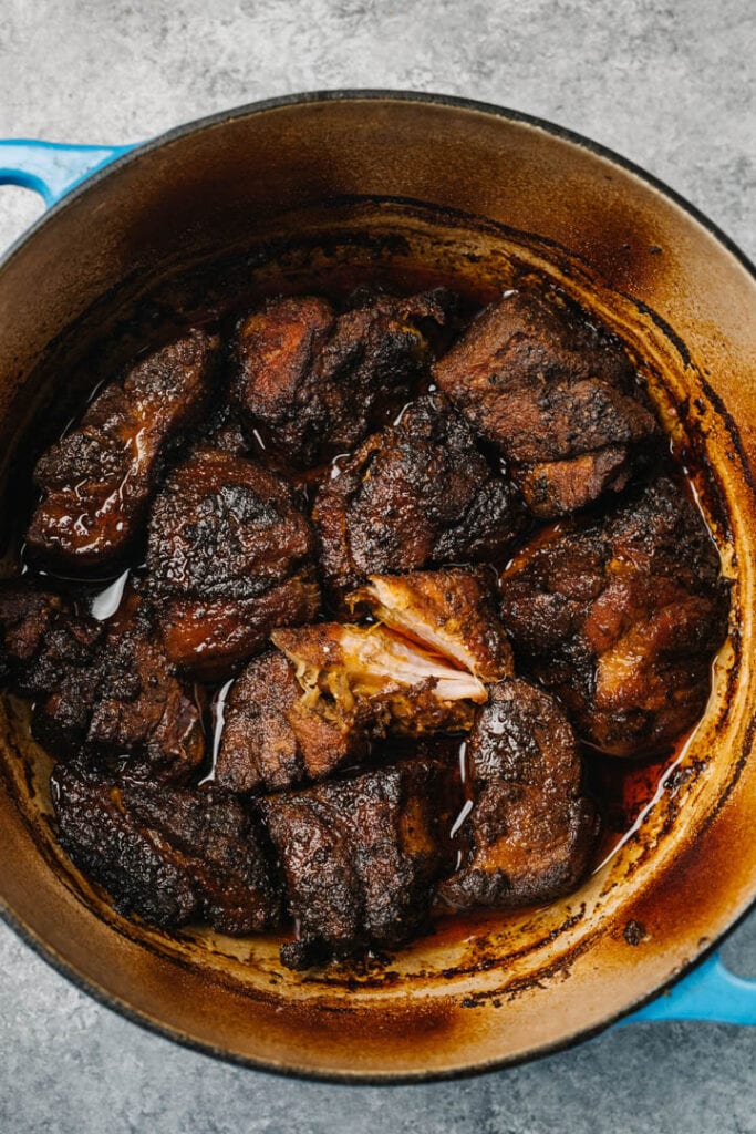 Oven roasted pulled pork pieces in a dutch oven.
