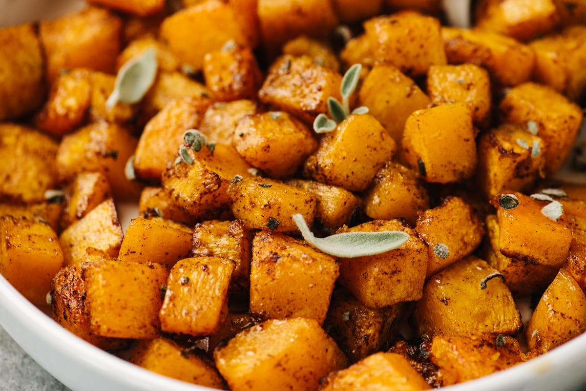 Side view, diced air fryer butternut squash in a white serving bowl.