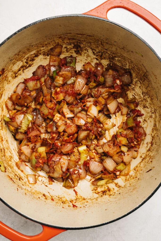 Tomato paste worked into sauteed onion, leek, and garlic in a dutch oven.