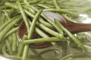 Blanched green beans in a pot of salted boiling water.