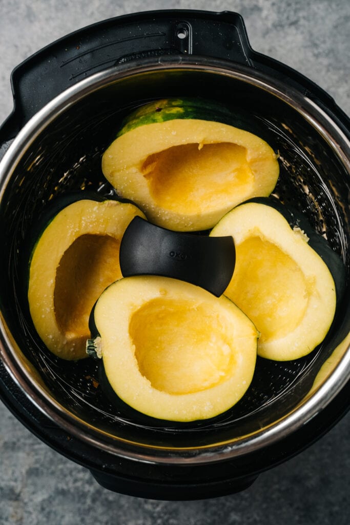 Acorn squash halves arranged in an instant pot.