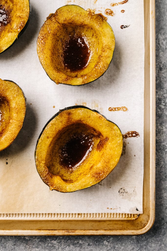 Instant pot acorn squash halves drizzled with butter, then sprinkled with brown sugar and cinnamon.