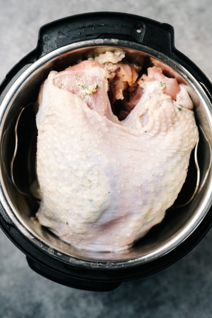 A raw turkey breast on a trivet in an instant pot.