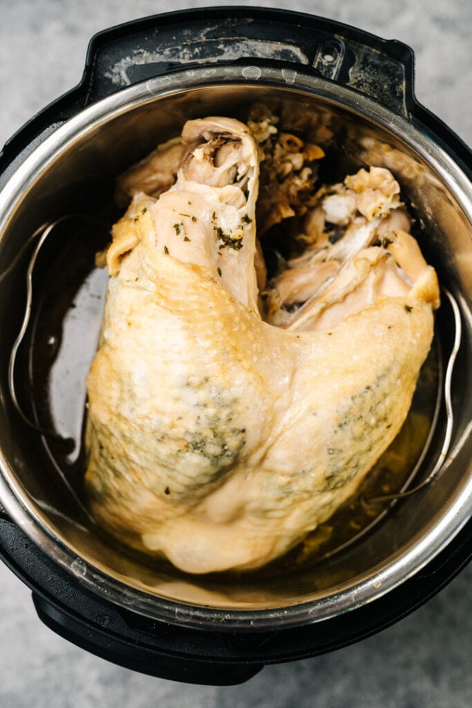 A cooked turkey breast on a trivet in an instant pot.
