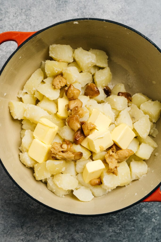 Butter and roasted garlic cloves added to cooked potatoes.