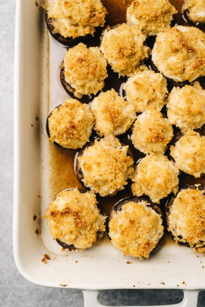 Crispy crab stuffed mushrooms in a casserole dish, fresh from the oven.