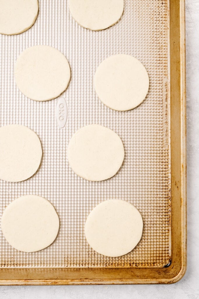 Cut out gluten free sugar cookies on a baking sheet.